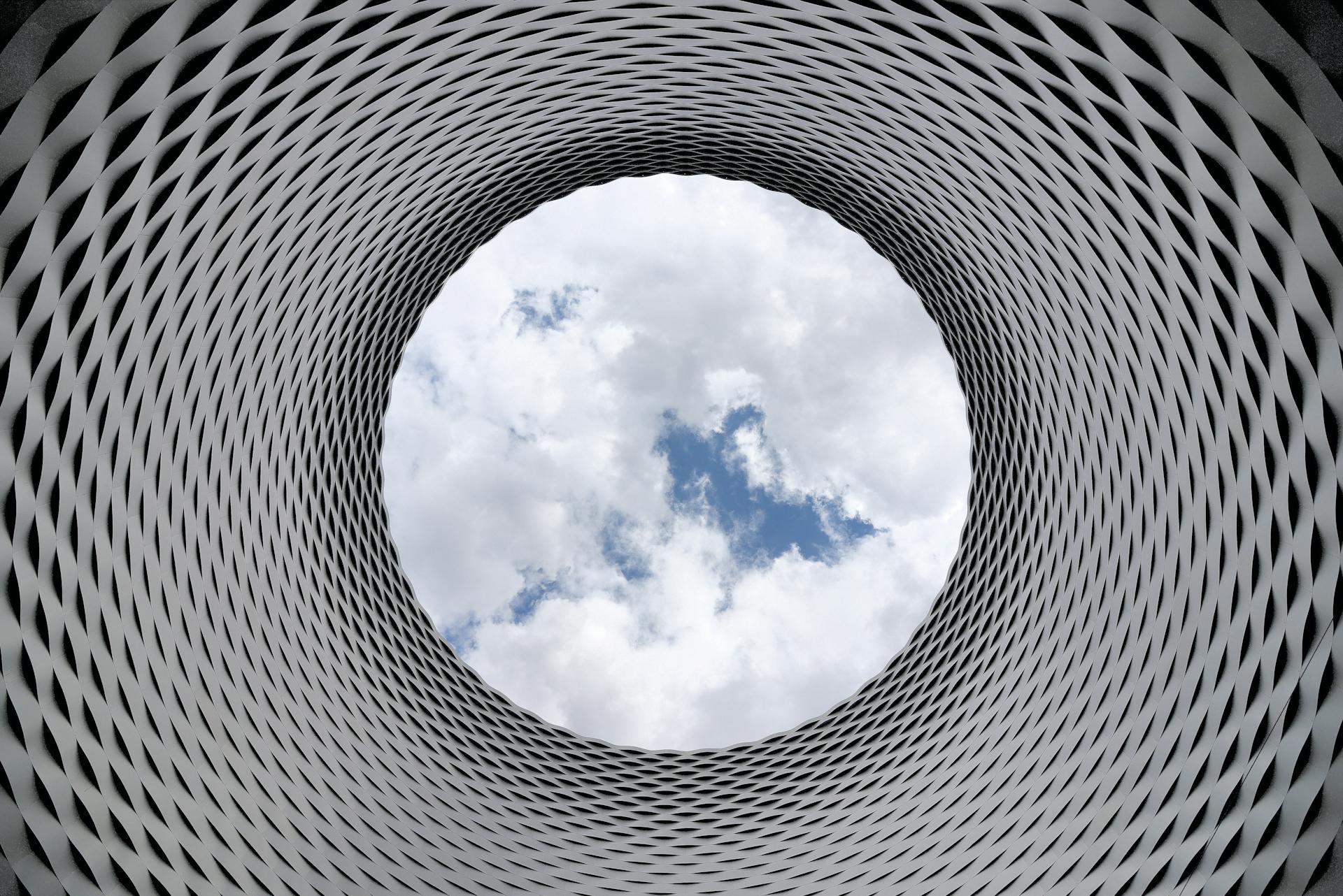 photo of the sky from inside a vertical tunnel